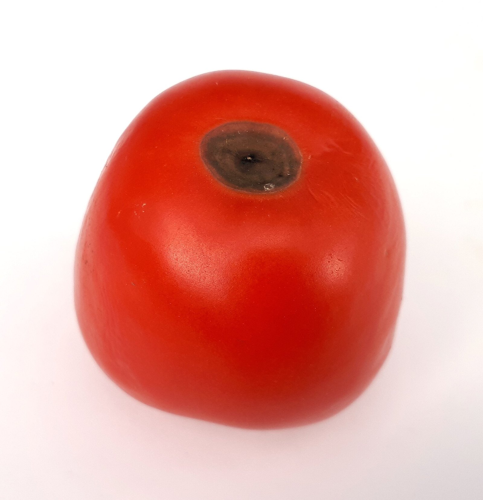 Red tomato fruit with a dark sunken lesion at its blossom end